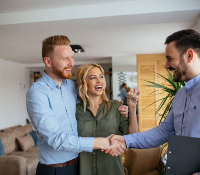 Portrait of financial adviser congratulating to a young couple for buying a new house.